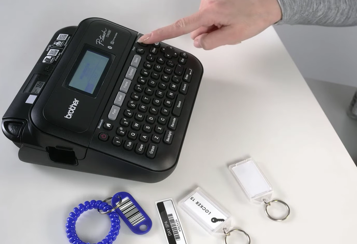 Label maker with keychain labels on a desk